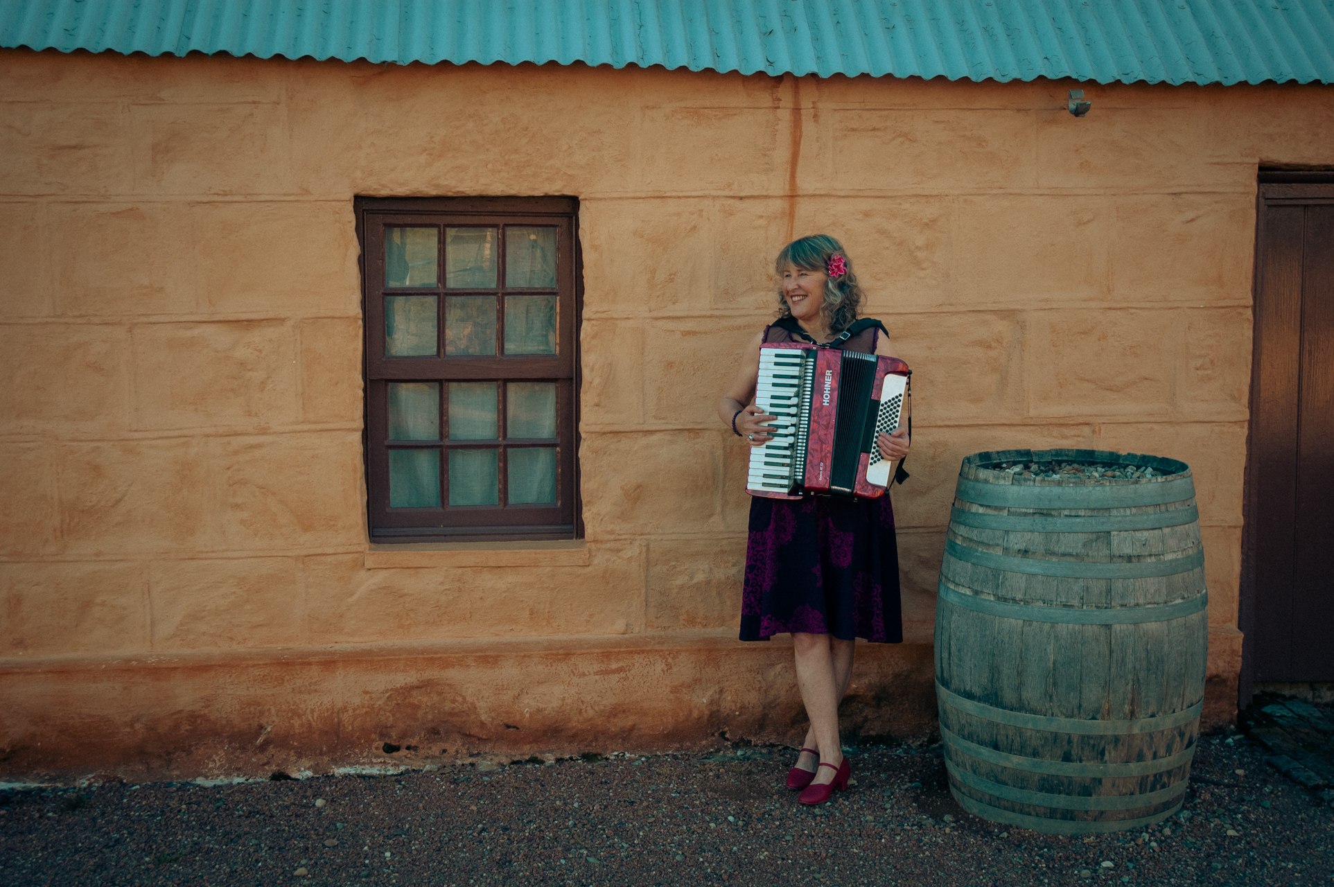 Queen Juanita played her accordion in front of a heritage homestead